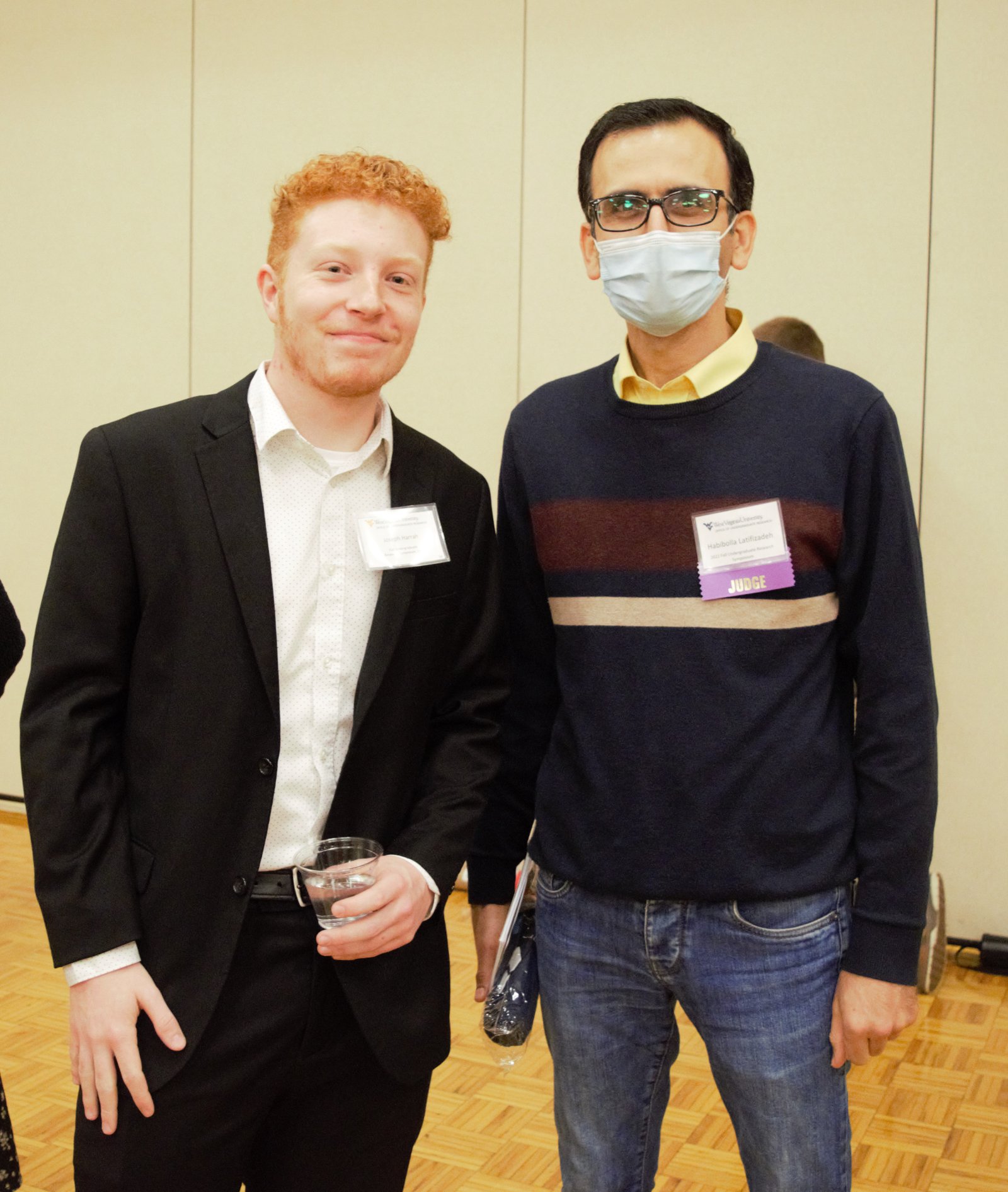 Habib Latifizadeh wearing a JUDGE badge beside a student presenter at the WVU Undergraduate Research Symposium, 2023
